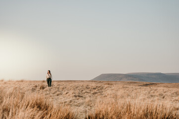woman walking through field with mountain in background