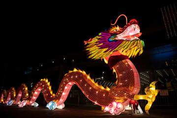 A huge colorful bright glowing chinese dragon Lun during the Chinese New Year celebration. Lantern festival during night. © Dragan