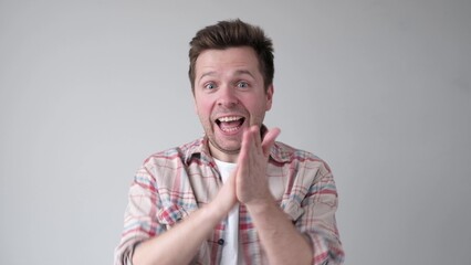 Young man smiling with glee as he rubs his hands together