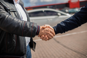 Сlose up. People shaking hands with each other..Successful car sale-purchase transaction.