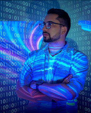 Software Developer / Hacker Working on a Virtual Computer, Projected Code Numbers and Characters Reflect on His Face. Dark Room in the metaverse. Abstract technology code. Hacking or Programming.