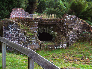 Beautiful view of a stone cave in the garden against trees and palm trees