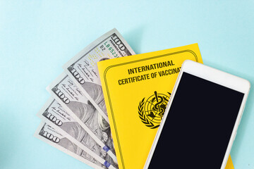 Fake Yellow international certificate of vaccination, make for money with empty mock up screen smart phone. Vaccination, disease immunity passport concepts