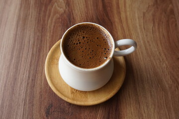 Fototapeta premium a cup of foamy turkish coffee on the wooden table