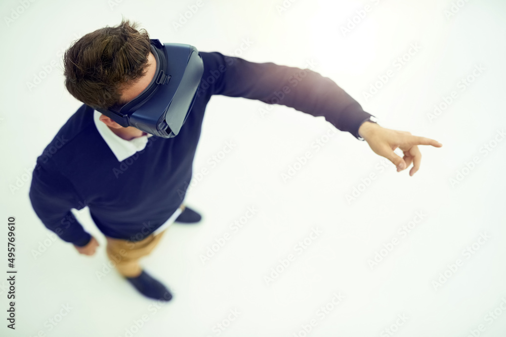 Poster Logged in to the virtual world. High angle shot of a businessman wearing a VR headset while connecting to a user interface in an office.