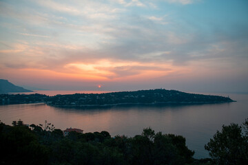 Fototapeta na wymiar Panorama lors d'un lever de soleil sur la presqu'île du Cap Ferrat depuis la petite batterie de Nice sur la Côte d'Azur