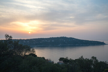 Obraz na płótnie Canvas Panorama lors d'un lever de soleil sur la presqu'île du Cap Ferrat depuis la petite batterie de Nice sur la Côte d'Azur