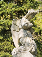 Ancient stone statue of a sad, grieving angel