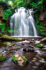 Fototapeta na wymiar A waterfall flows, Lynn Falls, Caaf Water, Lynn Glen, Dalry, North Ayrshire, Scotland, UK