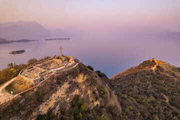 Aerial view of fortress with a cross on a hill in the background Lake Garda. Panorama on the rocca di manerba top view.