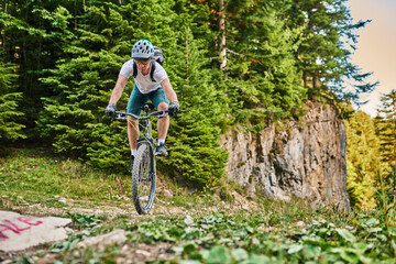 Fototapeta premium Cyclist Riding the Bike on the Trail in the Forest. Man cycling on enduro trail track. Sport fitness motivation and inspiration. Extreme Sport Concept. Selective focus