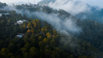 Clouds over the mountains with green trees