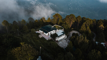 Aerial view of beautiful homes in green hills surrounded by trees 