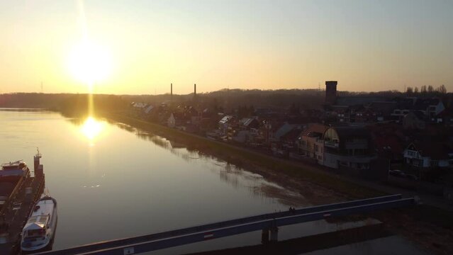Bright sunset over coastal river town with pier, aerial drone view