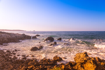 Rocks on the shore of the famous surfing beach of Canallave at sunset, Dunas de Liencres Natural Park and Costa Quebrada, Cantabria, Spain