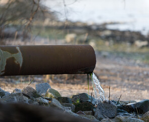 rostiges Rohr endet im Strand