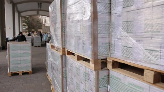 Cardboard boxes on a wooden pallet. Delivery concept. Worker with pallet fork truck stacker in warehouse loading group of cardboard boxes. Logistic, storage, shipment, industry, manufacturing concept