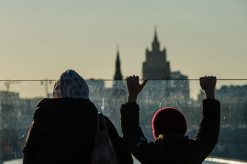 Mother and child look out over the Kremlin and the Ministry of Foreign Affairs from the observation...