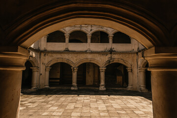 Hallway in a former 17th century Convent in central Mexico, with details of worn paint on the quarry walls and huge white arches. The symmetry of the place gives it a spectacular appearance.