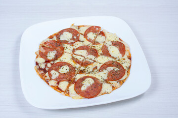 Traditional tomato, cheese, oregano pizza on red checkered napkin
