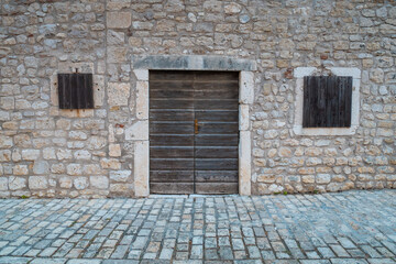 Stone wall with doors and windows.