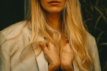 Close-up shot of a young blonde woman with long hair wearing a beige blazer