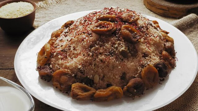 Couscous with dried fruits and orchids in a plate on a napkin next to cereals and milk