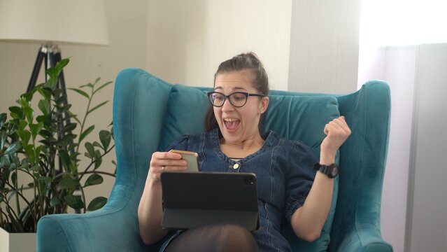 Young Woman Working Laptop Using IT. Happy Lady celebrating victory, shaking hands in hooray gesture, say yes. Working On Computer Browsing Internet result success. rewards and achievements concept - Powered by Adobe