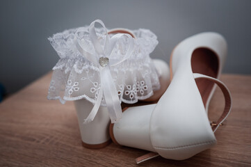 White shoes and bridal garter. Bride morning. Bride's accessories