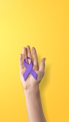 Hands holding purple ribbon on background. International Epilepsy Day. Alzheimer's disease. World...