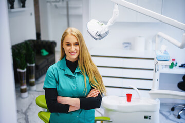 Portrait of female dentist .She standing in her dentist office.