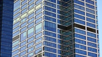 Glass building with transparent facade of the building and blue sky. Structural glass wall reflecting blue sky. Abstract modern architecture fragment. Contemporary architectural background.