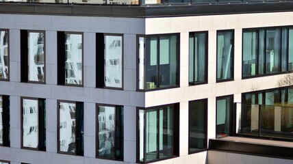 Glass building with transparent facade of the building and blue sky. Structural glass wall reflecting blue sky. Abstract modern architecture fragment. Contemporary architectural background.