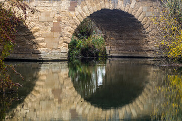 Reflection of a stone bridge on the river, Thames River in England