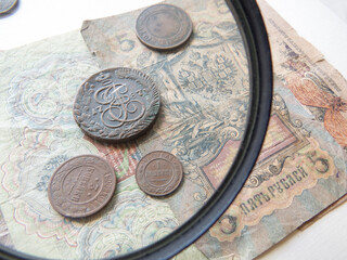 Pile of vintage metall (copper) coins. Magnifying glass and   coins of the Russian Empire in the background kopyur. Antikvariat. Numismatics vintage background