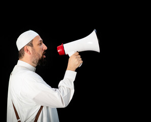 Fototapeta premium Muslim pilgrim in white traditional clothes, saying message on megaphone. High quality photo