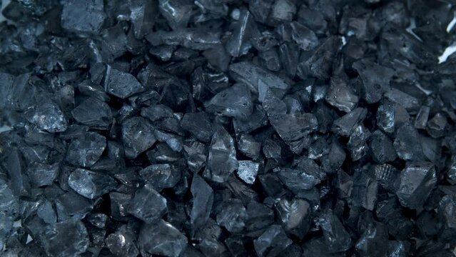 The texture of glass black pieces shimmers and glitters.Industry,mining.Advertising concept of precious stones and minerals.