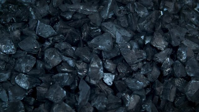 The texture of glass black pieces shimmers and glitters.Industry,mining.Advertising concept of precious stones and minerals.