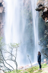 Joven excursionista disfrutando de la cascada del Salto de la novia, situado en la localidad de Navajas (Castellón) - obrazy, fototapety, plakaty