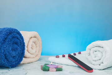 Wrapped towels with candles and a nail file on a granite base