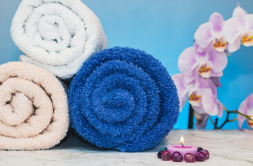 Towels rolled with candles and colored stones on a granite base