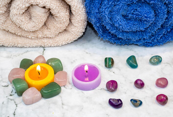 Towels rolled with candles and colored stones on a granite base