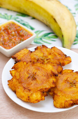 
Patacones or fried tostones of green or ripe plantain, with a crispy texture, accompanied by a tomato and onion stew called 