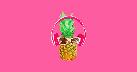 Close up of funny pineapple listening to music in headphones on pink background