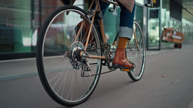 Stylish hipster man riding on vintage bicycle. follow camera, midsection shot