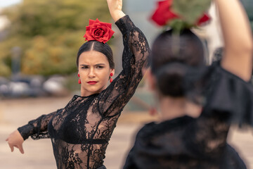 spanish young girl dancing flamenco with red earrings, red rose and lips painted red - obrazy, fototapety, plakaty