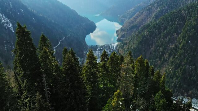 Clear blue mountain lake with reflection of clouds on the water. Drone view