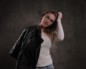 Close-up of a young attractive woman against dark grey background - studio photography