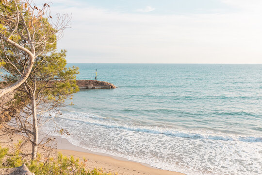 Gorgeous view of Comarruga, Spain with a calm blue sea under a bright sky on a sunny day