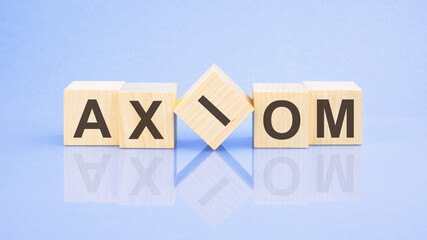 text AXIOM - letters by on woodens blocks on pale lilac background, in concept of business and corporation
